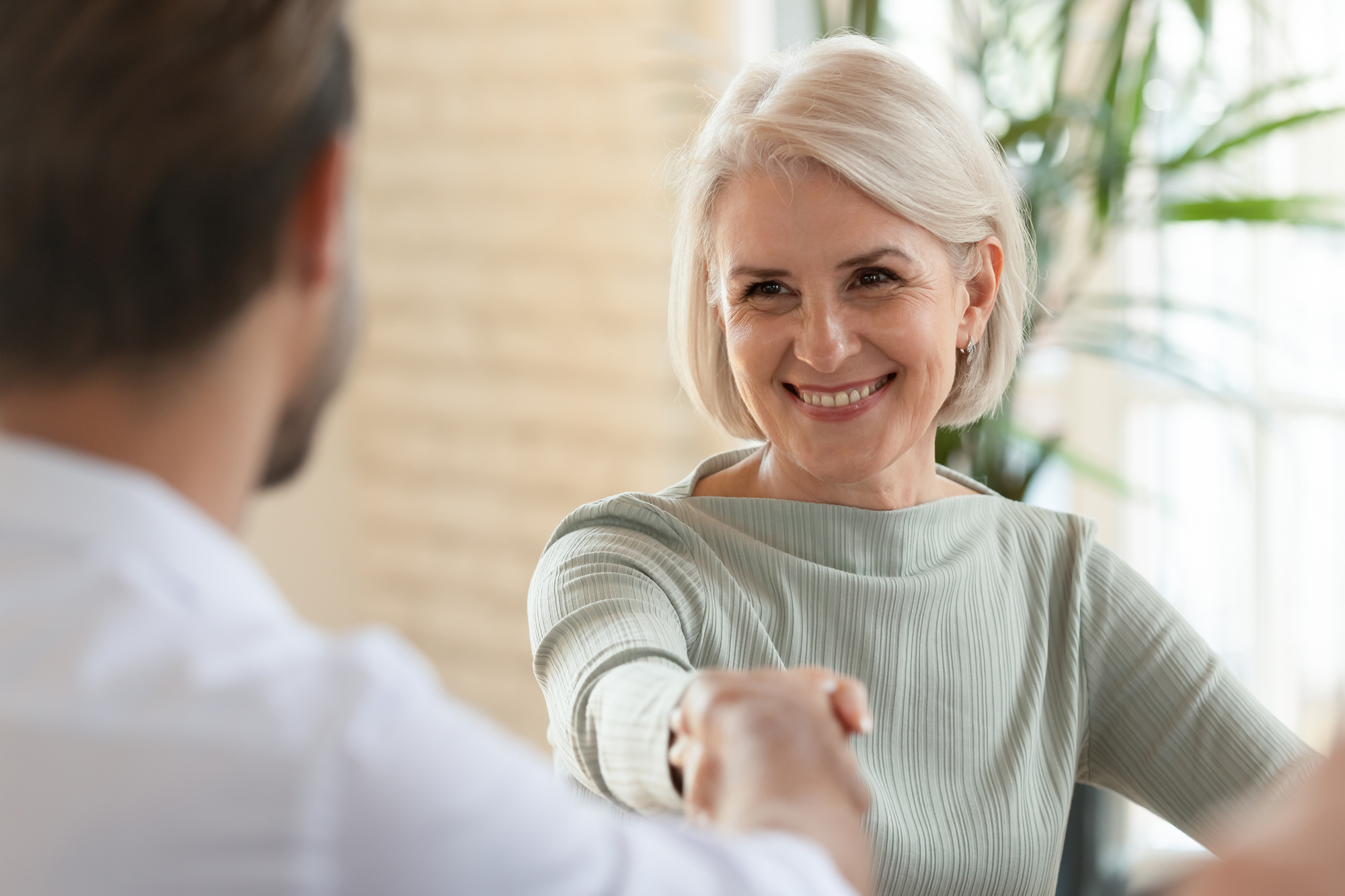 Retired woman shaking her financial planner's hand