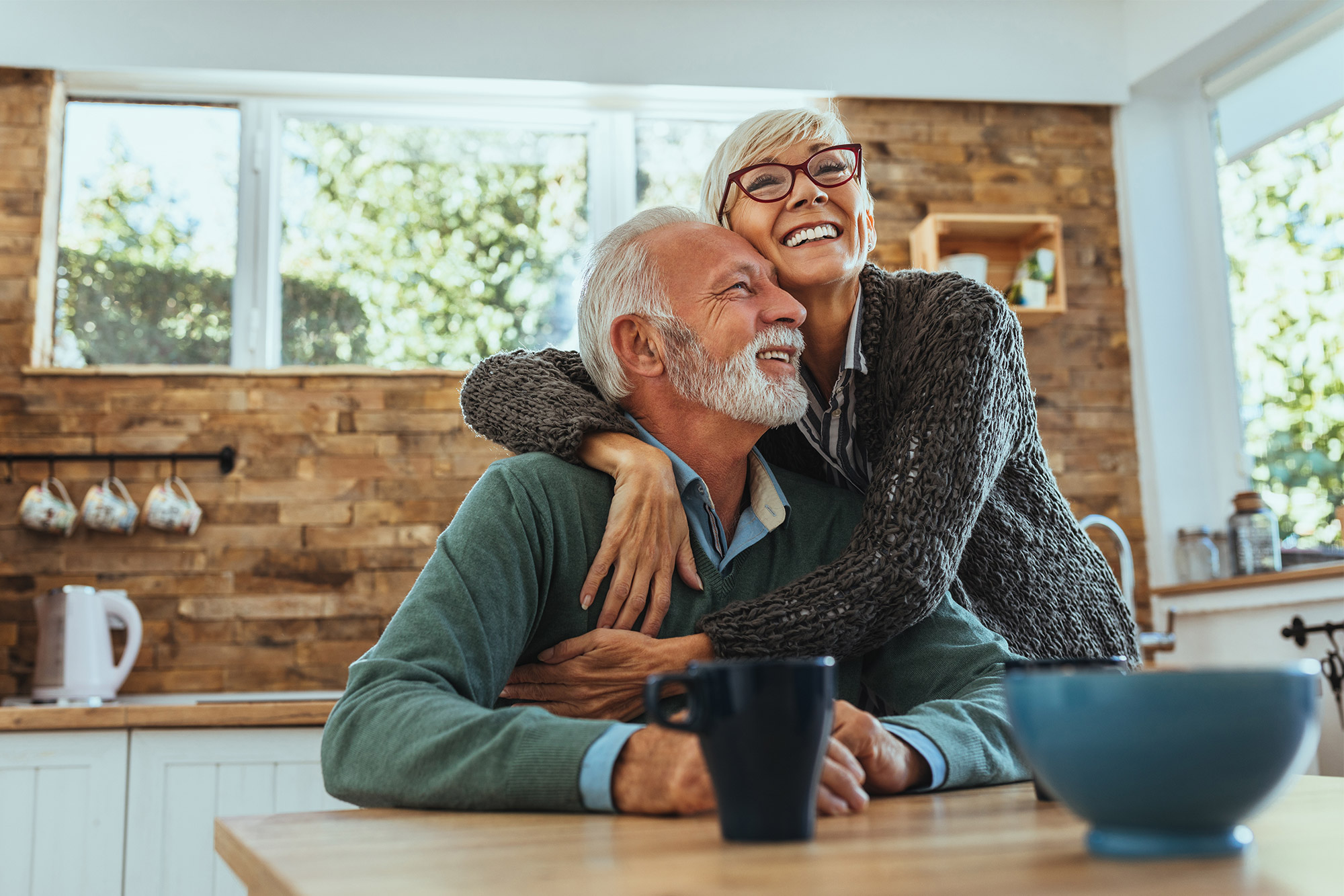 Retired couple embracing in kitchen